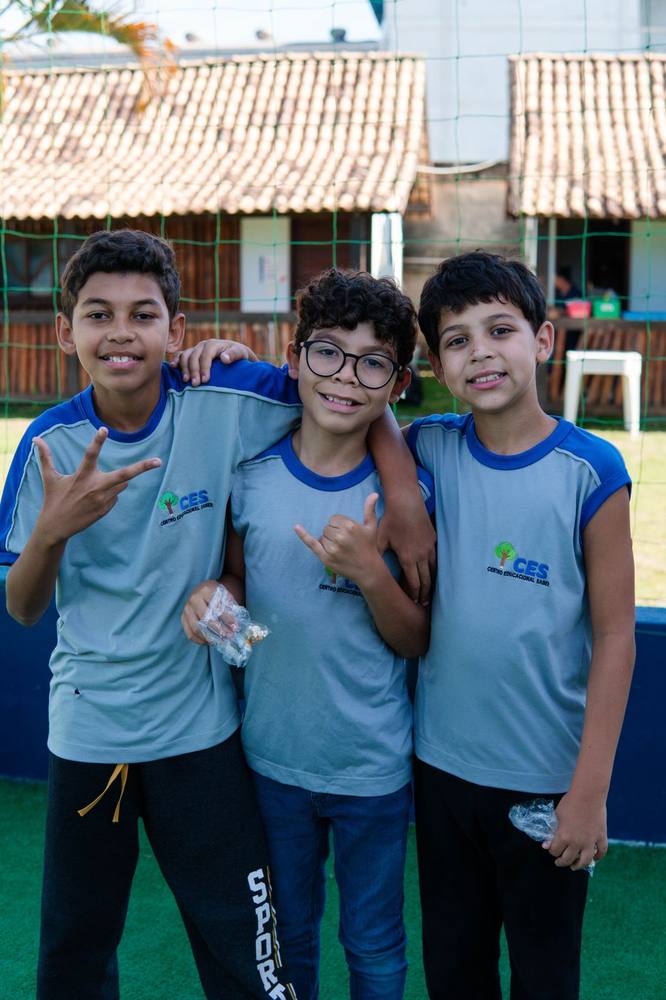 Três alunos do CES abraçados na quadra